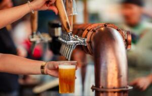 a bartender dispensing a pint of craft beer